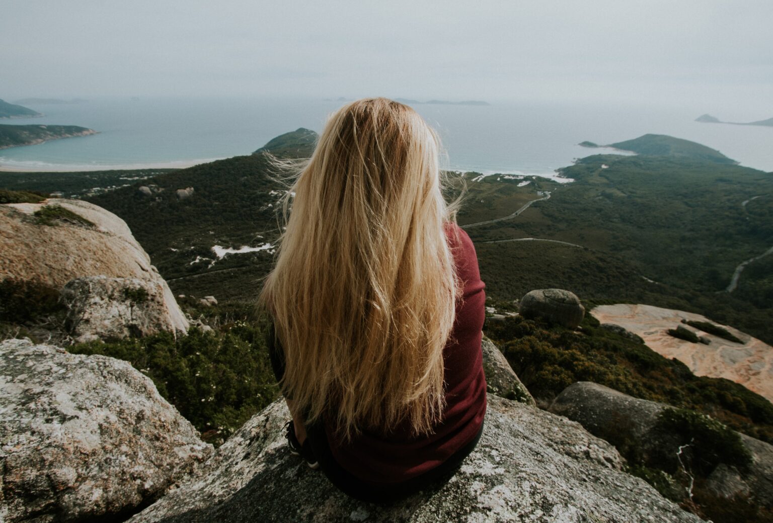 woman sitting on top mountain